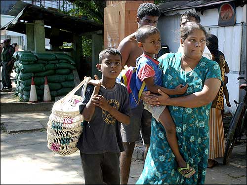 A family moves away from their low-lying home in the capital Colombo following the massive tidal waves.