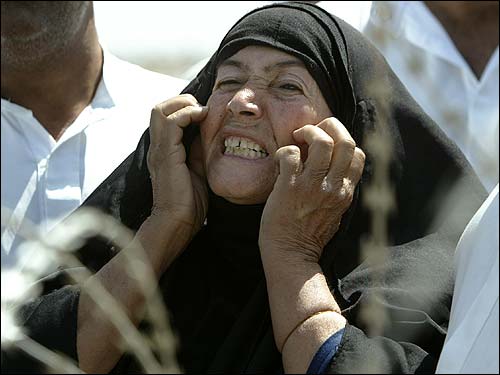 A mother of an Iraqi arrested by US forces scratches her face
