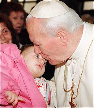 Pope John Paul II kissed an infant during his visit to the parish of Our Lord of Valme in Rome.
