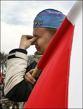 A Pole carrying a Polish flag wept as he took part in an open air Mass in commemoration of Pope John Paul II in Krakow Friday. Pope John Paul II served as a priest and bishop in Krakow.