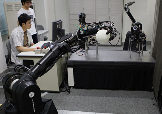 The pitching robot - in the foreground - prepares to throw a pitch to the batting robot in the background. The pitching robot, with its three-fingered hand, can throw 90 percent of its pitches in the strike zone. Although it can throws a plastic foam ball at 25 miles per hour, Ishikawa is hoping to increase the speed to 93 mph and make it able to throw off-speed pitches like curves and sliders.
