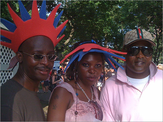 Henry Kabali, left, Ehsa Kabali, and Patrick Ssenabulya wear foam crowns being given away free on the Esplanade.
