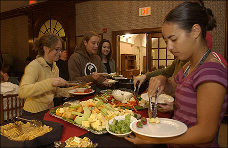 Smith College students Megan McRobert (L) and Tessa Robinson (R) helped themselves to a buffet dinner at the Wilder House dining hall, where most of them live.