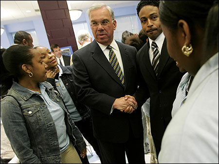 During a visit to the New Boston Pilot Middle School this month, Mayor Thomas M. Menino greeted academy leader DaQuall Graham, while students La’Shee Branch (L) and Curissa Dunbar waited to meet him.