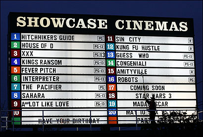 Paul Cuscuna changes titles at Showcase Cinemas in Revere. Most theater chains have stuck with old-fashioned signs because they're less expensive and easier to read in sunlight than electronic boards.