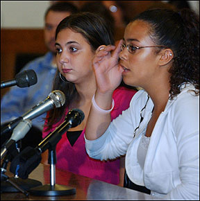 Eduarda DaRosa (right), a freshman at Everett High School who testified on Beacon Hill yesterday, pointed to her head as she described to lawmakers how she was injured by a bully.