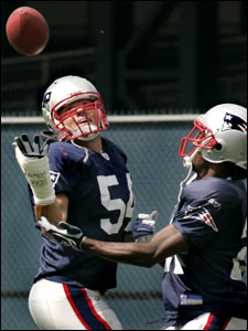 With the words ‘‘Bear Down’’ on his cast, Tedy Bruschi looks up to catch the ball during a drill with Randall Gay at practice.