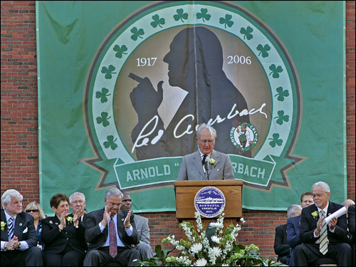 Cousy talks to the crowd with Auerbach's silhouette in the background.