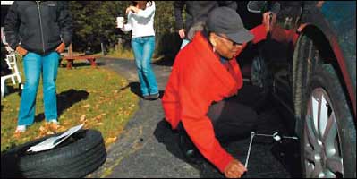Jackie Thompson learns to change a tire at a Ladies Start Your Engines! auto repair class for women in Philadelphia.