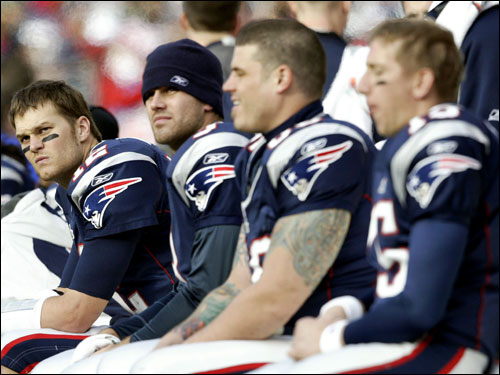 Tom Brady (left) looked on from the bench in the first half.