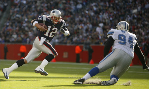 Patriots quarterback Tom Brady (left) scrambled around Detroit Lions defensive tackle Marcus Bell.