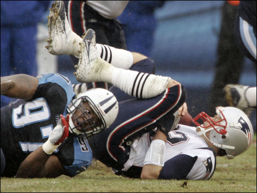Patriots quarterback Tom Brady (right) was sacked by Tennessee Titans defensive tackle Tony Brown (97) for a five-yard loss in the first quarter.