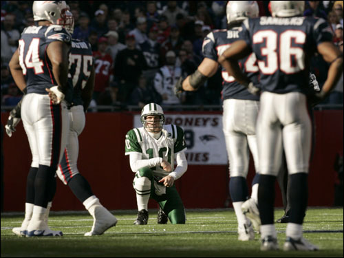 Jets quarterback Chad Pennington (center) paused after being hit hard by the Patriots.