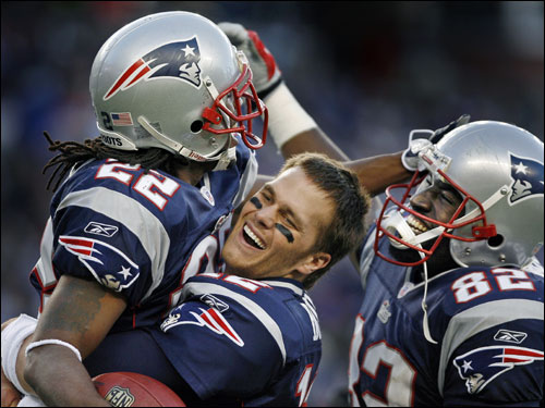 Patriots cornerback Asante Samuel (22) received a hug and a lift from quarterback Tom Brady (center) and a big smile from tight end Daniel Graham (82) following Samuel's fourth-quarter interception return for a touchdown that sealed New England's win.