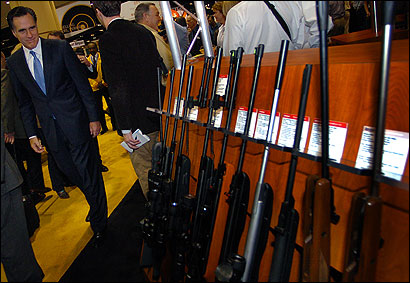 Presidential prospect Mitt Romney checked out a display of shotguns Friday during his NRA-guided tour of a sprawling gun trade show in Orlando, Fla.