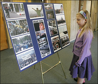 Talene Pogharian, 8, viewed photographs of Armenian rights advocate Hrant Dink, below, at St. James Armenian Church in Watertown yesterday.