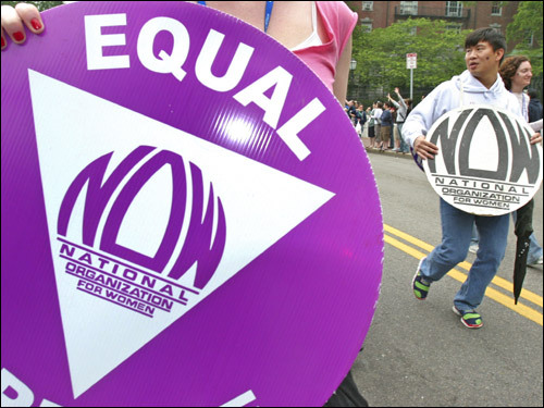 Austin Lin, right, of NOW makes his way up Beacon Street during the annual gay pride parade.