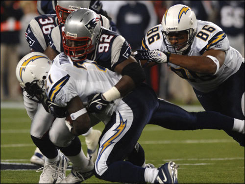 Chargers running back LaDainian Tomlinson was wrapped up by Patriots defensive lineman Santonio Thomas.