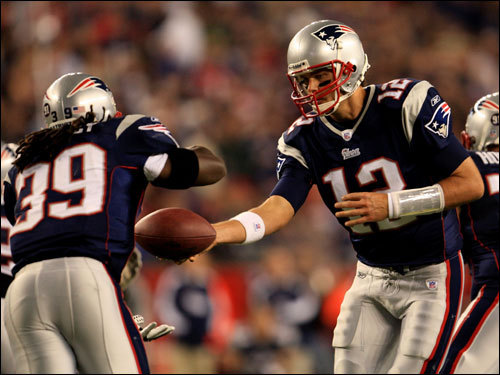 Tom Brady (right) handed the ball off to Laurence Maroney during the game.