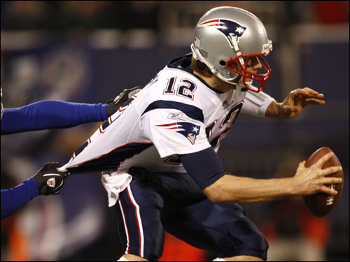 Tom Brady (12) tried to escape a sack in the game.