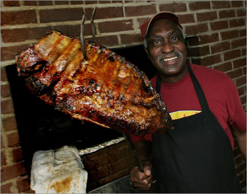 Bobby Brant pulls a slab of ribs off the grill at Dreamland Bar-B-Que in Tuscaloosa, Ala.