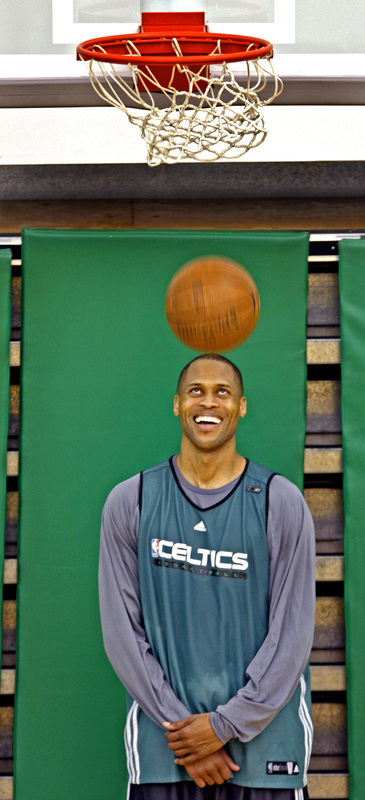 Celtics forward P.J. Brown smiles as he watches a free throw from teammate James Posey (not pictured) go through the net.