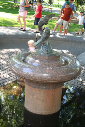 Even without water, people can always find ways to enjoy fountains. The third of the four series of similar fountains is a cat-like animal with a bird in its claw, and although there is only a small puddle of dark water at the bottom of the nonflowing fountain, the little girl in the background was happy to run around in circles inside the practically empty basin.