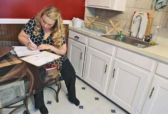 Julia Norman, who recently lost her teaching job in Sudbury, fills out last-minute paperwork before leaving her Waltham home for an interview. She has sent out 83 resumes.