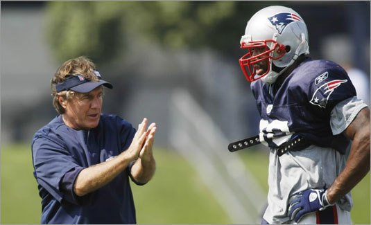 Coach Bill Belichick (left) signals to the defense alongside linebacker Shawn Crable.