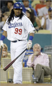 Manny Ramirez (99) waits to hit as owner and chairman, Frank McCourt looks on.