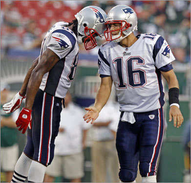 As the clock winds down in the game, Patriots quarterback Matt Cassel (right) extends a hand of congratulations to wide reciever Randy Moss (left), but Moss prefers a helmet to helmet tap as his way of celebrating.