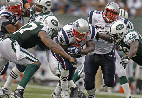 Patriots running back LaMont Jordan (32, center) bulls through the Jets Calvin Pace (left) and David Harris (right) for some yardage.