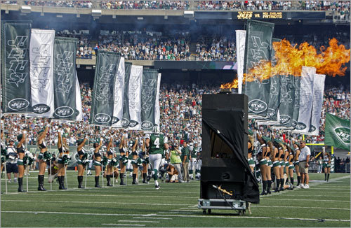 Jets quarterback Brett Favre runs the gauntlet of flags and fire as he is introduced for his first home game in a New York uniform