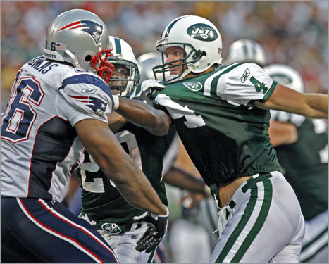 Patriots linebacker Adalius Thomas has Jets quarterback Brett Favre by the shirt as he begins the process of sacking him in the fourth quarter of New England's 19-10 victory. New York running back Leon Washington is in the middle.