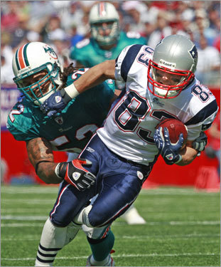 Wes Welker is hauled down by Miami linebacker Channing Crowde.