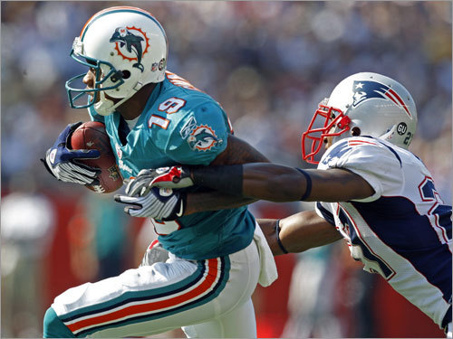 Miami's Ted Ginn, Jr. tries to break away from Ellis Hobbs after a catch.
