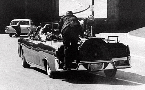 Nov. 22, 1963: John Kennedy lies dead in the back of the Lincoln as Jacqueline Kennedy leans over him. A Secret Service agent stands on the bumper.