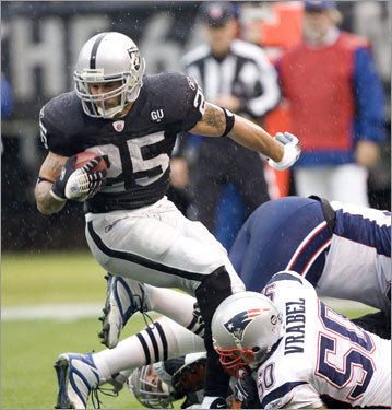Raiders running back Justin Fargas (L) was pulled down by Mike Vrabel.