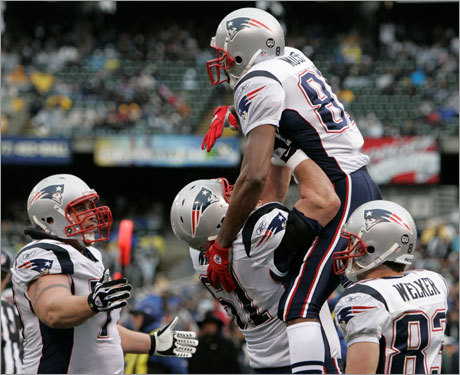Randy Moss was mobbed by his teammates. He caught two touchdown passes on the day.
