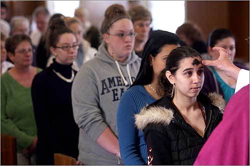 Regis College student Desiree Tavarez and fellow students and staff lined up to receive ashes from campus minister Father Paul Kilroy.