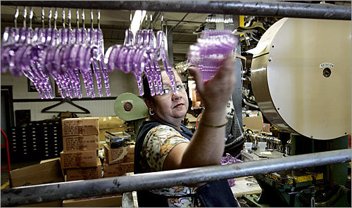 Blanca Tavares of Nashua assembles hangers for a children's clothing label.