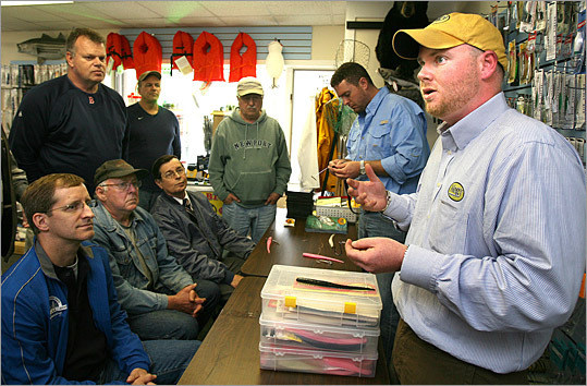 Michael Hogan, right, of Falmouth teaches local fishermen how to use and rig the plastic fishing lures he makes. He used his layoff severance pay from AT&T to start 'Hogy,' his lure company.