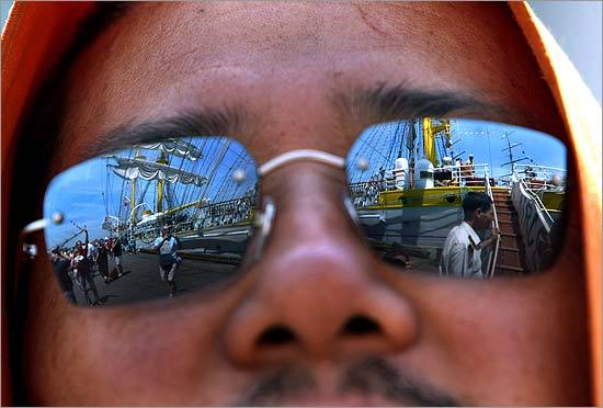 The tall ship Mircea from Romania was reflected in the sunglasses of Lama Sonam as he waited in line to board the ship.