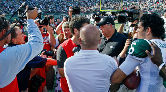 Patriots head coach Bill Belichick (far left) and Jets head coach Rex Ryan (right with hat) shake hands briefly at the center of the field following New York's 19-9 victory of New England Sunday afternoon. Jets rookie quarterback Mark Sanchez is at far right.