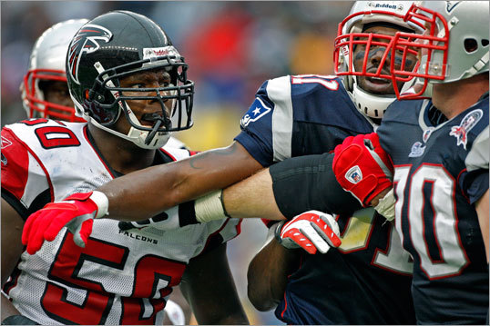Randy Moss (center) played peacemaker as he got between Falcons LB Curtis Lofton (left) and Patriots guard Logan Mankins (right) during a post-play skirmish.