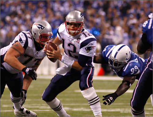 Tom Brady (12) eludes the rush of Indianapolis Colts defensive end Robert Mathis (98) to make the completion for the New England Patriots third touchdown of the game to Julian Edelman in the second quarter.
