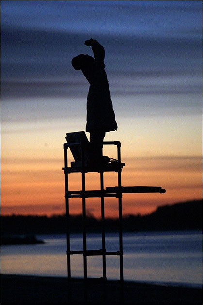 Silhouetted against the sunrise, Hyunji Lee, of Boston, stood on a lifeguard chair to snap a photo of the Leonid meteors streaming over Hyannis on Nov. 19, 2002.