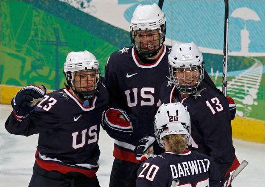 Julie Chu (13) of the US celebrated with teammates Kerry Weiland (23), Jinelle Zaugg-Siergiej (27) and Natalie Darwitz (20) after scoring a goal against China. The US defeated China, 12-1.