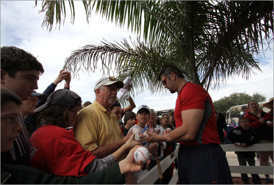 Catcher Jason Varitek signs autographs for fans on the first day of official workouts for pitchers and catchers and the opening of spring training to the public.