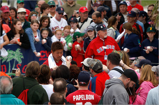 Pitcher Daisuke Matsuzaka signs autographs for fans on the first official day of workouts for pitchers and catchers and the first day that spring training was open to the public.